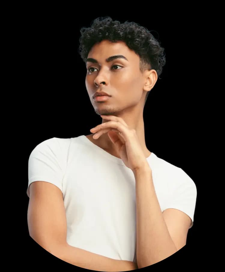 A young person with medium skin tone and short curly hair, wearing a white T-shirt. They have a thoughtful expression with one hand resting on their chin.